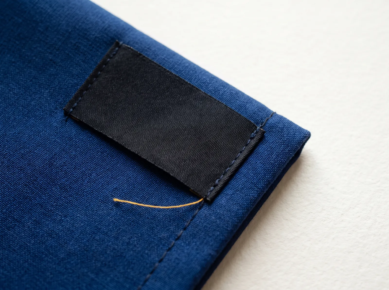 Black woven label without lettering on cobalt blue fabric
