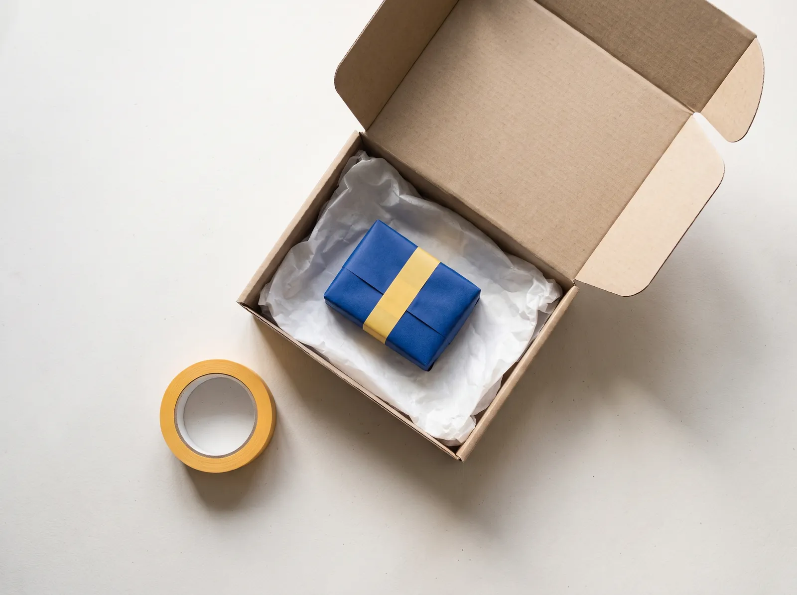 Gepackter Versandkarton mit Seidenpapier und blau verpacktem Produkt